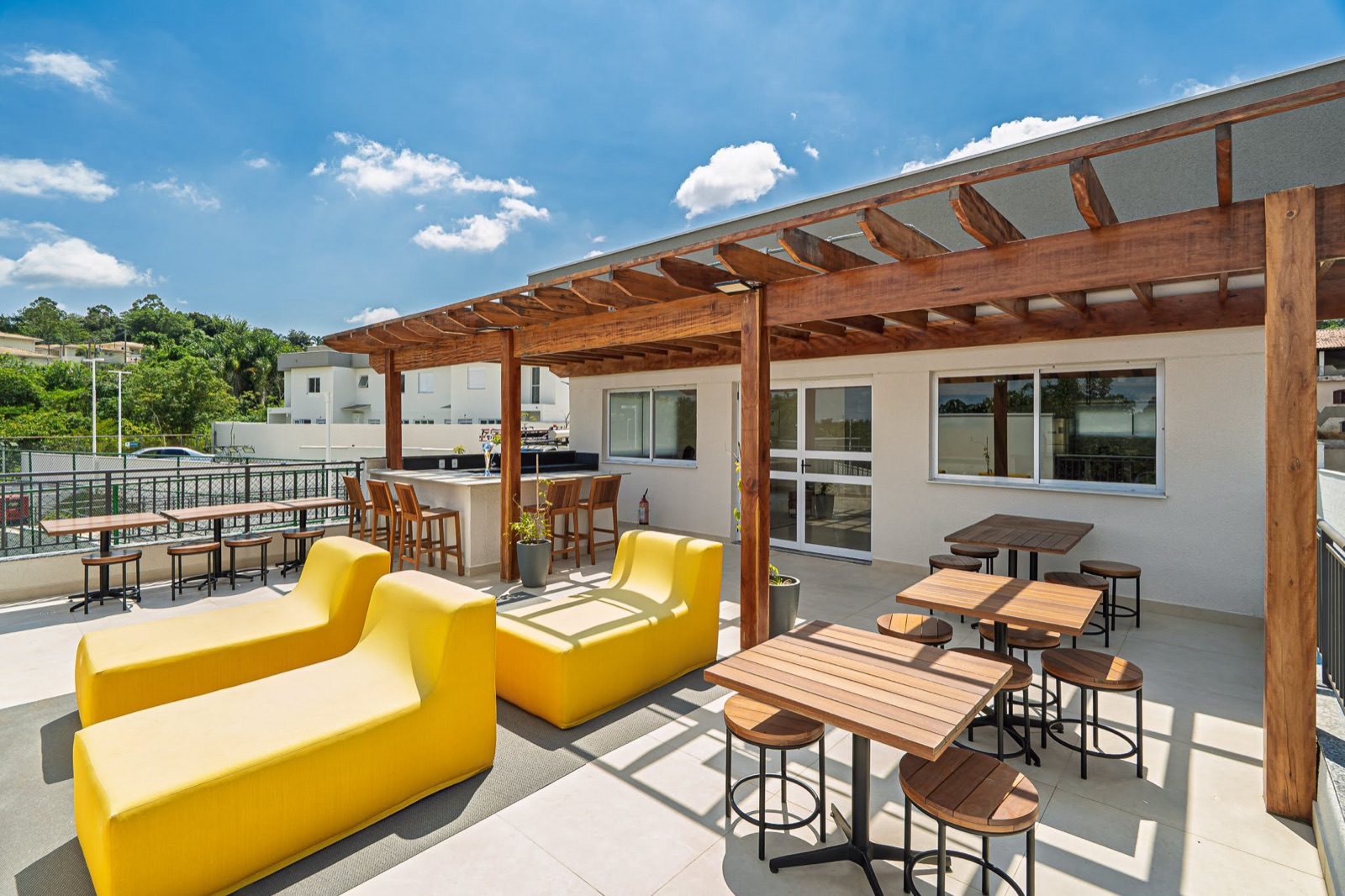 Lounge externo com pergolado e mobiliário